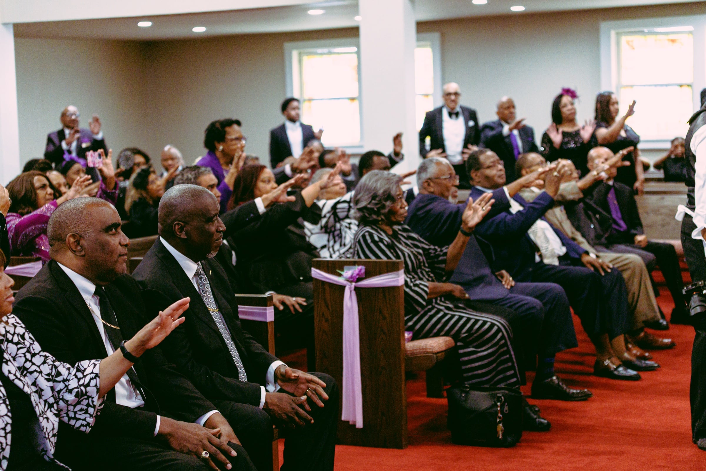 Audience members responding with raised hands during a church event
